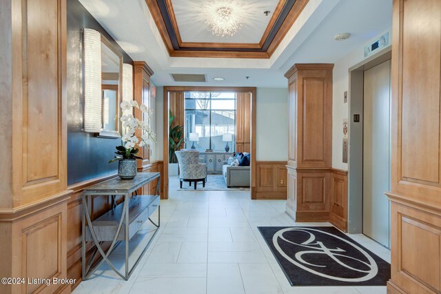 1 Riverpointe Plz Unit 1112, Jeffersonville, IN 47130 - foyer entrance featuring wainscoting, crown molding, elevator, a tray ceiling, and decorative columns