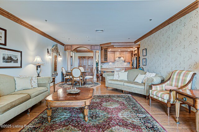1 Riverpointe Plz Unit 1112, Jeffersonville, IN 47130 - living room featuring crown molding, decorative columns, wood finished floors, and baseboards