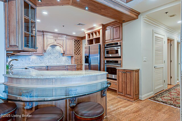 1 Riverpointe Plz Unit 1112, Jeffersonville, IN 47130 - kitchen with appliances with stainless steel finishes, light stone counters, light wood-style flooring, a sink, and recessed lighting
