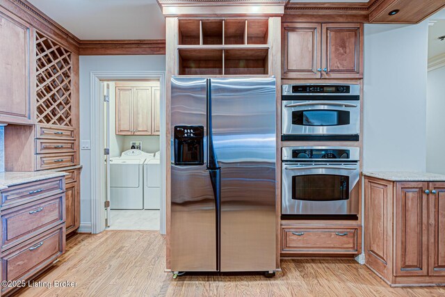 1 Riverpointe Plz Unit 1112, Jeffersonville, IN 47130 - kitchen with appliances with stainless steel finishes, washer and dryer, light wood-style floors, light stone counters, and crown molding