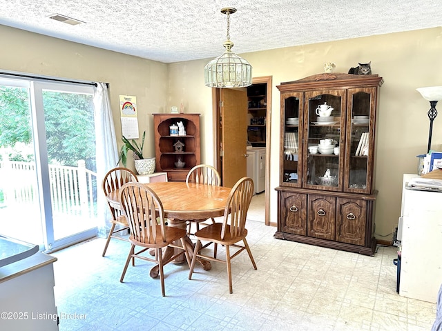 186 Lillian Ave, Elizabethtown, KY 42701 - dining space featuring a chandelier, a textured ceiling, light flooring, and washing machine and dryer