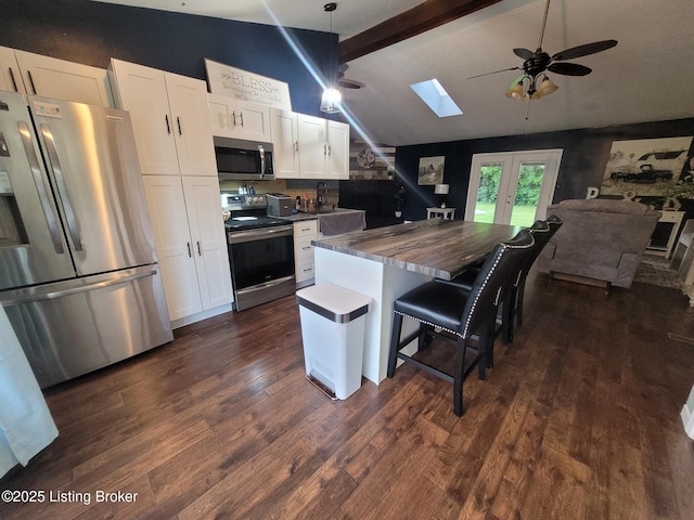 3007 Cline Ct, Carrollton, KY 41008 - kitchen with stainless steel appliances, a skylight, a ceiling fan, white cabinetry, and dark wood-type flooring