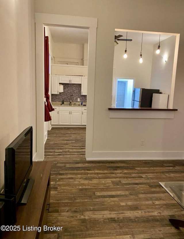 809 S Shelby St, Louisville, KY 40203 - unfurnished living room with dark wood-style flooring, a sink, and baseboards