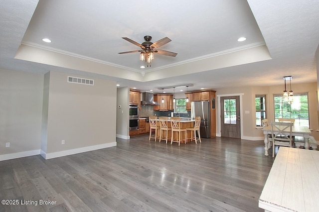 2004 Kepley Rd, Georgetown, IN 47122 - kitchen with a tray ceiling, stainless steel appliances, wall chimney exhaust hood, ornamental molding, and recessed lighting