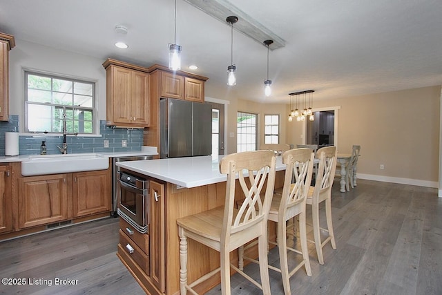 2004 Kepley Rd, Georgetown, IN 47122 - kitchen featuring a sink, stainless steel appliances, wood finished floors, decorative backsplash, and a kitchen bar