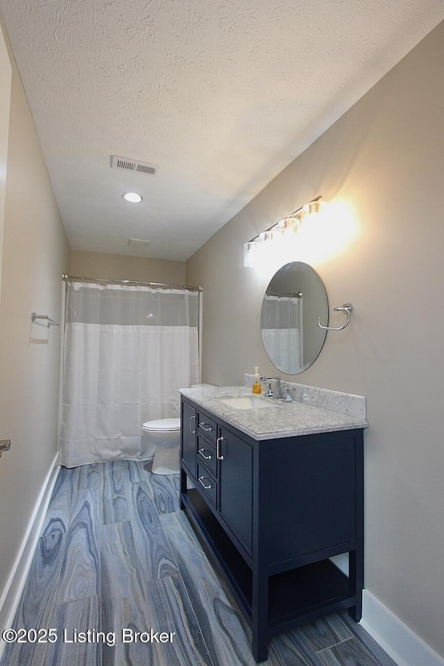 2004 Kepley Rd, Georgetown, IN 47122 - bathroom with baseboards, toilet, vanity, a textured ceiling, and wood finished floors