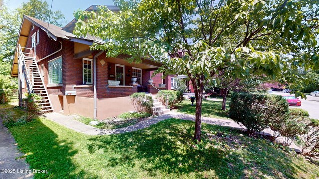 1344 S Brook St, Louisville, KY 40208 - view of home's exterior with stairway, brick siding, a yard, and covered porch