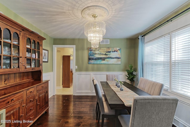 1007 Girard Dr, Louisville, KY 40222 - dining area featuring a chandelier, dark wood-style flooring, wainscoting, and a decorative wall