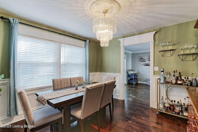 1007 Girard Dr, Louisville, KY 40222 - dining area with a chandelier, a wainscoted wall, a decorative wall, ornamental molding, and dark wood-type flooring