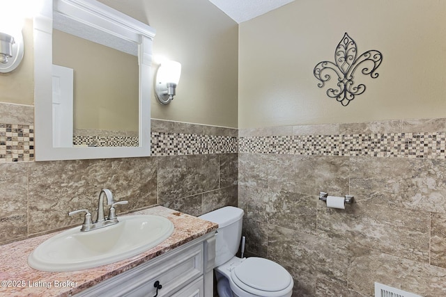 1007 Girard Dr, Louisville, KY 40222 - bathroom with toilet, vanity, tile walls, and wainscoting