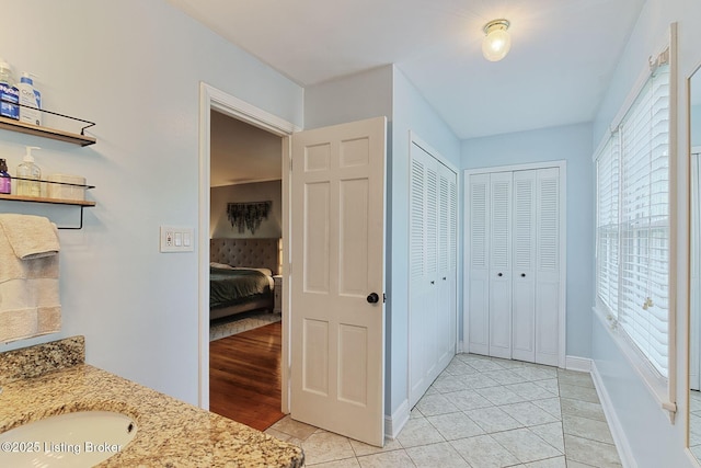 1007 Girard Dr, Louisville, KY 40222 - bathroom featuring a closet, vanity, tile patterned flooring, connected bathroom, and baseboards