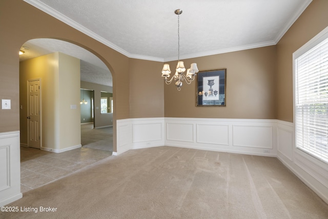 8811 Eli Dr, Louisville, KY 40291 - unfurnished room featuring arched walkways, light carpet, a chandelier, a wainscoted wall, and crown molding