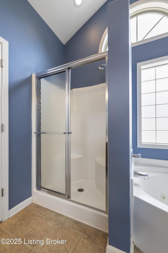 8811 Eli Dr, Louisville, KY 40291 - bathroom featuring a shower stall, a garden tub, healthy amount of natural light, lofted ceiling, and baseboards