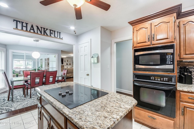 2508 Windsor Forest Dr, Louisville, KY 40272 - kitchen featuring black appliances, a ceiling fan, light stone countertops, light tile patterned floors, and a kitchen island