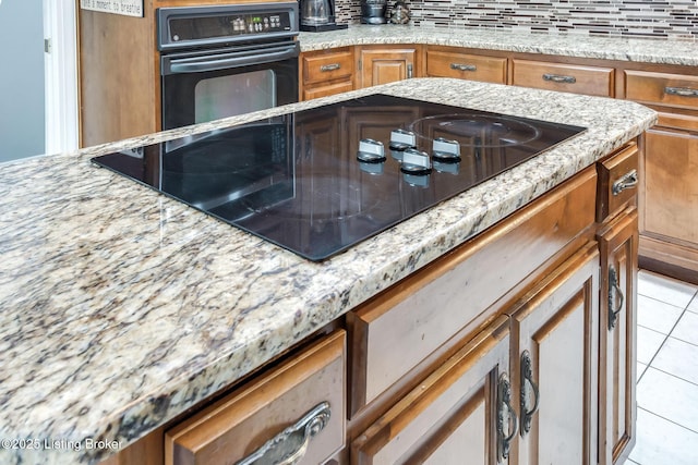 2508 Windsor Forest Dr, Louisville, KY 40272 - kitchen featuring black appliances, brown cabinetry, light tile patterned floors, and light stone countertops
