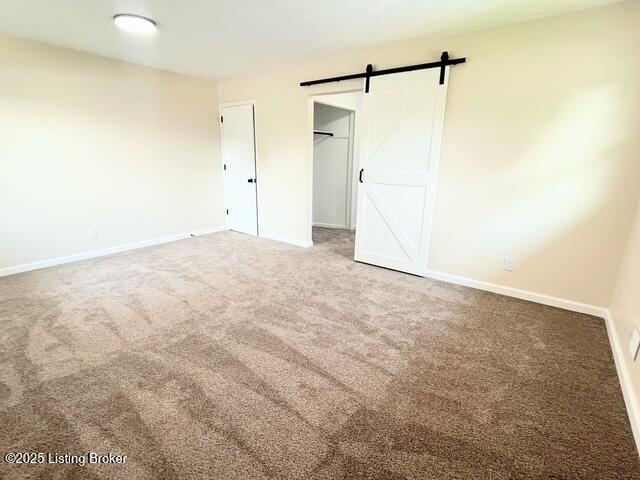 7402 Nottoway Cir, Louisville, KY 40214 - unfurnished bedroom featuring carpet, a barn door, and a closet