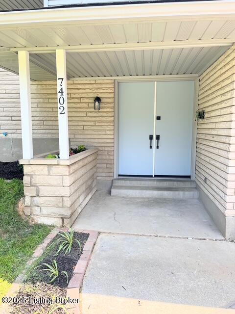 7402 Nottoway Cir, Louisville, KY 40214 - property entrance featuring covered porch and brick siding