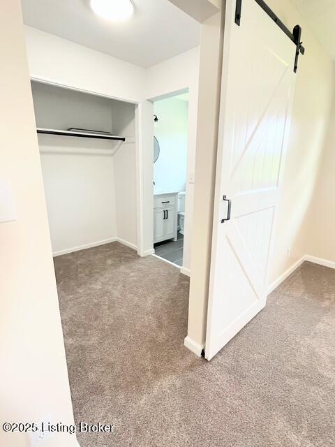 7402 Nottoway Cir, Louisville, KY 40214 - unfurnished bedroom featuring carpet, a barn door, a closet, and ensuite bath