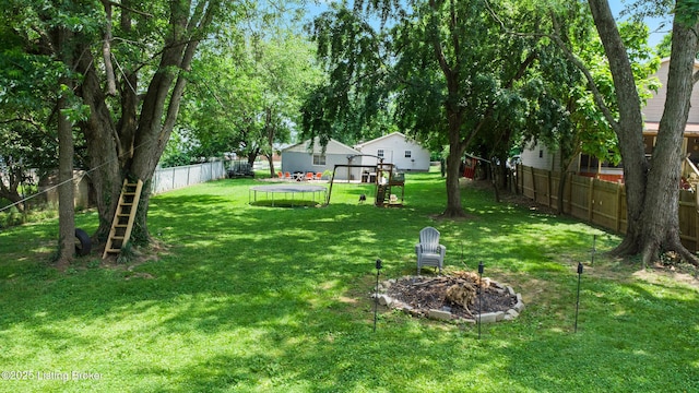 9712 Keys Ferry Rd, Fairdale, KY 40118 - view of yard featuring a trampoline, a fire pit, and a playground