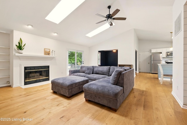 4303 Fence Pl, Louisville, KY 40241 - living area featuring ceiling fan, light wood-style floors, a skylight, a glass covered fireplace, and high vaulted ceiling