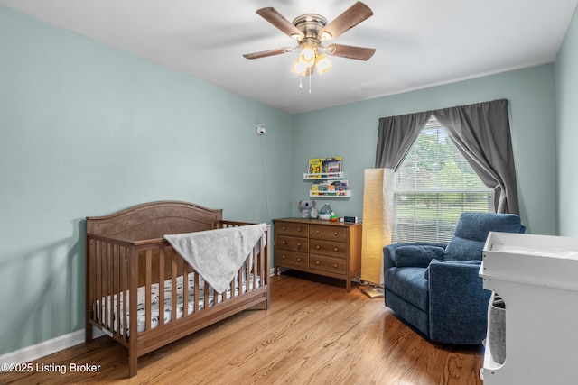 7007 Graymoor Rd, Louisville, KY 40222 - bedroom with wood finished floors, a ceiling fan, and a crib