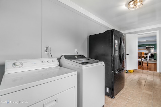 7007 Graymoor Rd, Louisville, KY 40222 - laundry room featuring washing machine and clothes dryer, crown molding, and light tile patterned floors