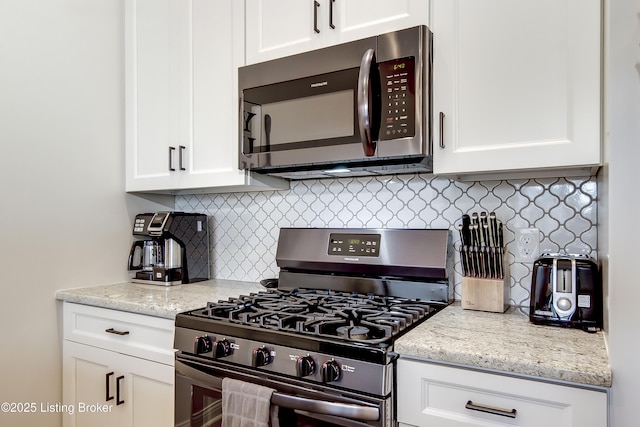 421 Marret Ave, Louisville, KY 40208 - kitchen with stainless steel appliances, white cabinetry, backsplash, and light stone counters