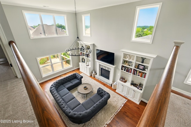 7811 Ingram Way, Crestwood, KY 40014 - living area featuring a chandelier, wood finished floors, baseboards, a fireplace, and a towering ceiling