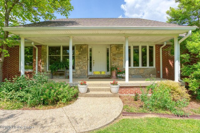 6311 Fible Ln, Crestwood, KY 40014 - view of exterior entry with a porch, roof with shingles, and stone siding