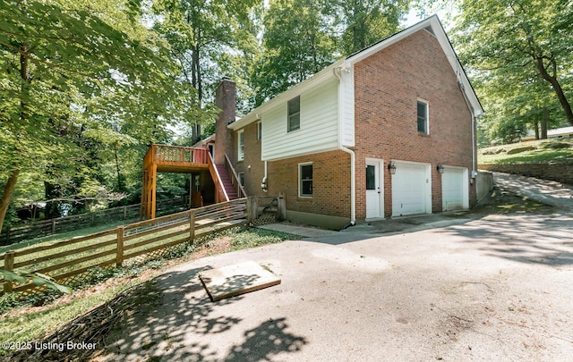 211 Rebel Dr, Pewee Valley, KY 40056 - view of side of property with stairs, a garage, brick siding, a chimney, and a wooden deck