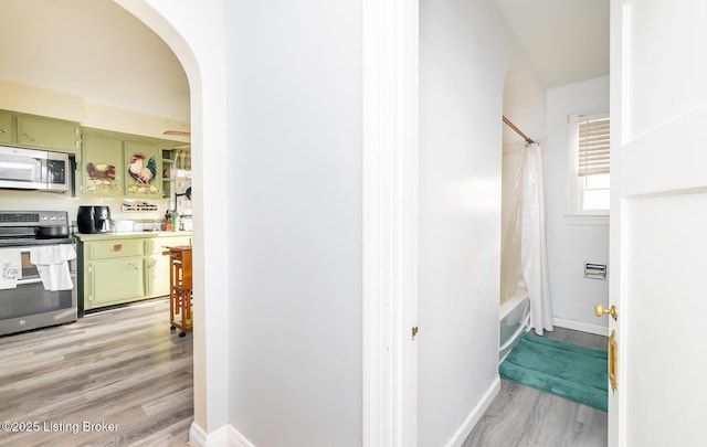 4825 Manslick Rd, Louisville, KY 40216 - hallway with light wood-style flooring, arched walkways, and baseboards