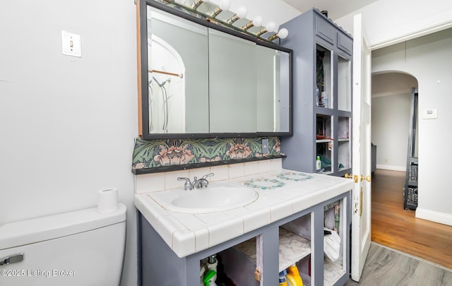 4825 Manslick Rd, Louisville, KY 40216 - bathroom featuring toilet, backsplash, wood finished floors, vanity, and baseboards