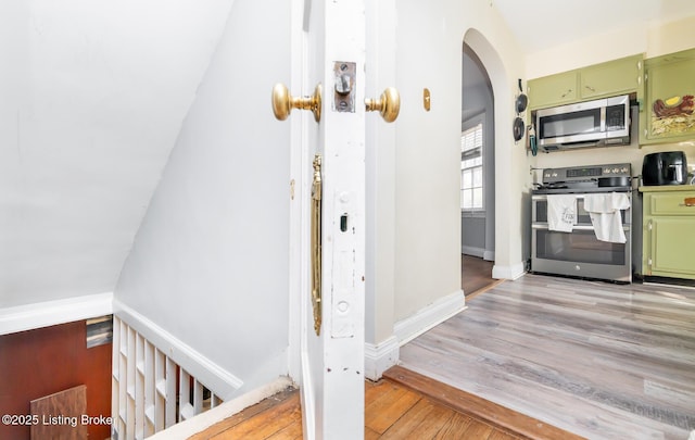 4825 Manslick Rd, Louisville, KY 40216 - kitchen with appliances with stainless steel finishes, green cabinets, arched walkways, light wood-style flooring, and baseboards