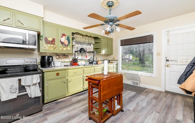 4825 Manslick Rd, Louisville, KY 40216 - kitchen with appliances with stainless steel finishes, green cabinets, light countertops, and light wood-type flooring