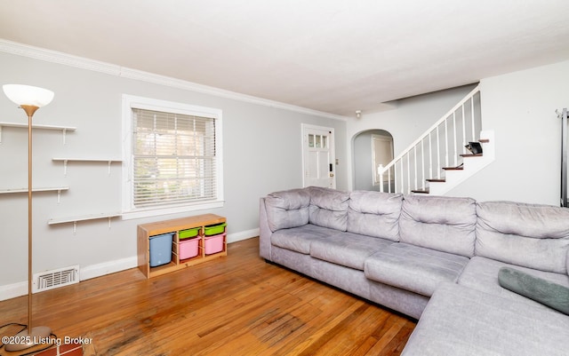 4825 Manslick Rd, Louisville, KY 40216 - living room with arched walkways, wood finished floors, ornamental molding, baseboards, and stairway
