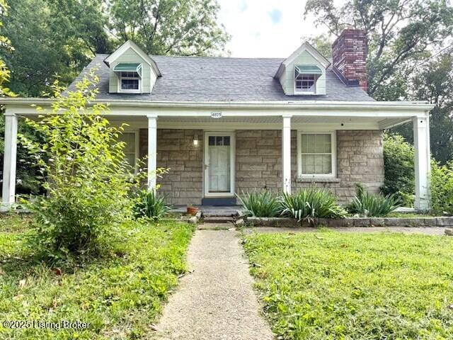 4825 Manslick Rd, Louisville, KY 40216 - cape cod-style house with a chimney, stone siding, covered porch, and a front lawn