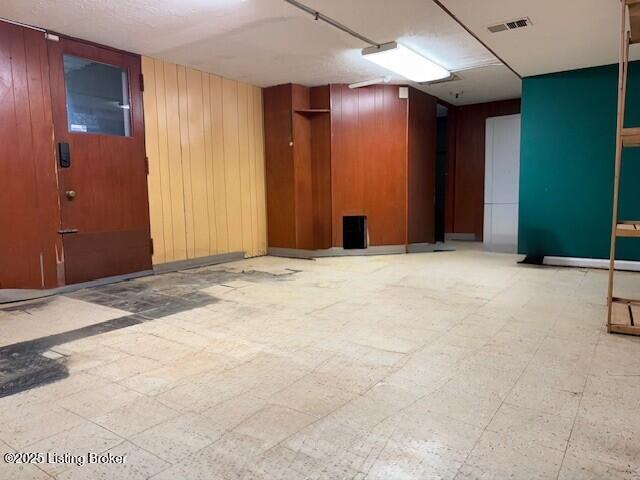 4825 Manslick Rd, Louisville, KY 40216 - below grade area with wooden walls and tile patterned floors