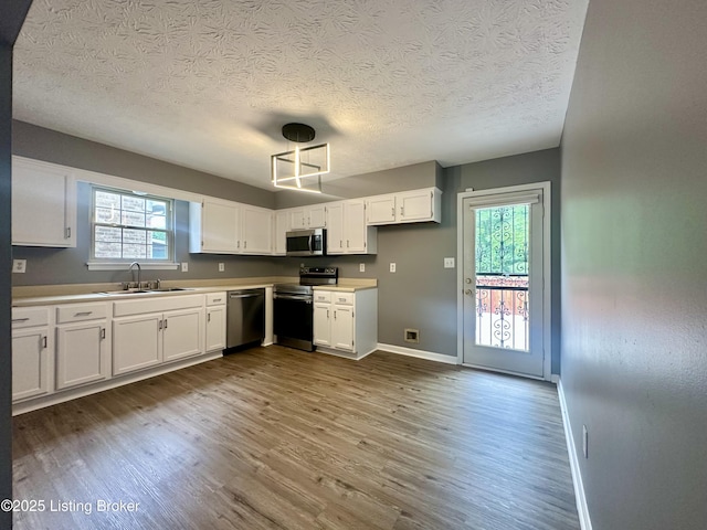 512 Auburn Oaks Dr, Louisville, KY 40214 - kitchen with stainless steel appliances, a sink, a textured ceiling, dark wood-style floors, and baseboards