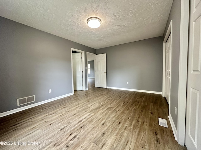 512 Auburn Oaks Dr, Louisville, KY 40214 - unfurnished bedroom featuring wood finished floors, baseboards, a textured ceiling, and a closet