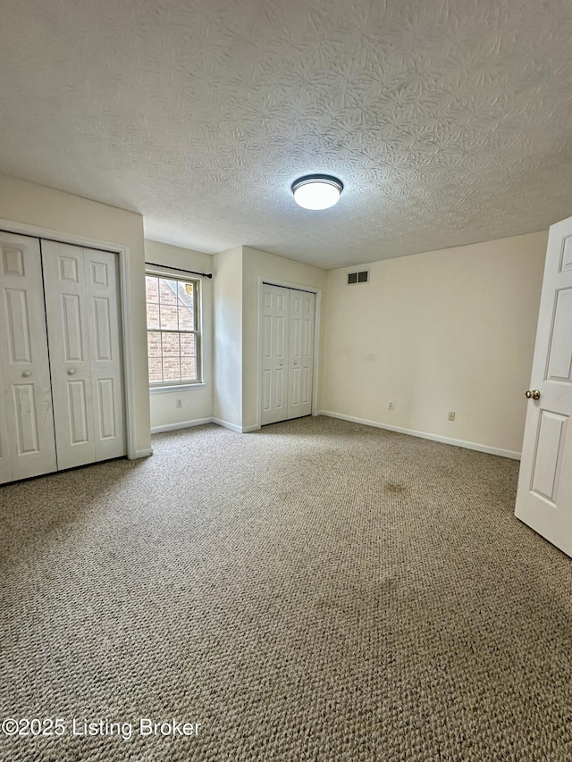 512 Auburn Oaks Dr, Louisville, KY 40214 - unfurnished bedroom featuring baseboards, carpet floors, a textured ceiling, and multiple closets