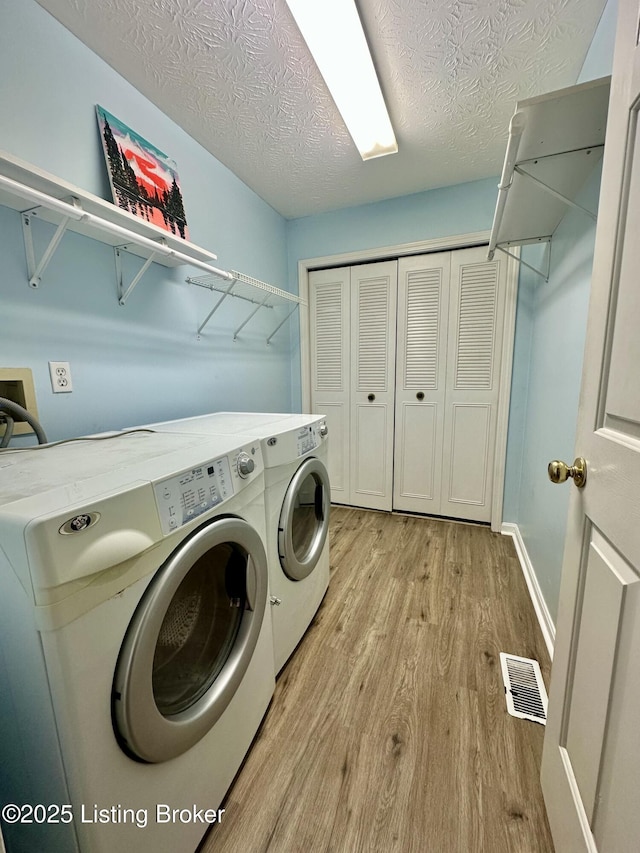 512 Auburn Oaks Dr, Louisville, KY 40214 - washroom with separate washer and dryer, light wood-type flooring, a textured ceiling, and baseboards