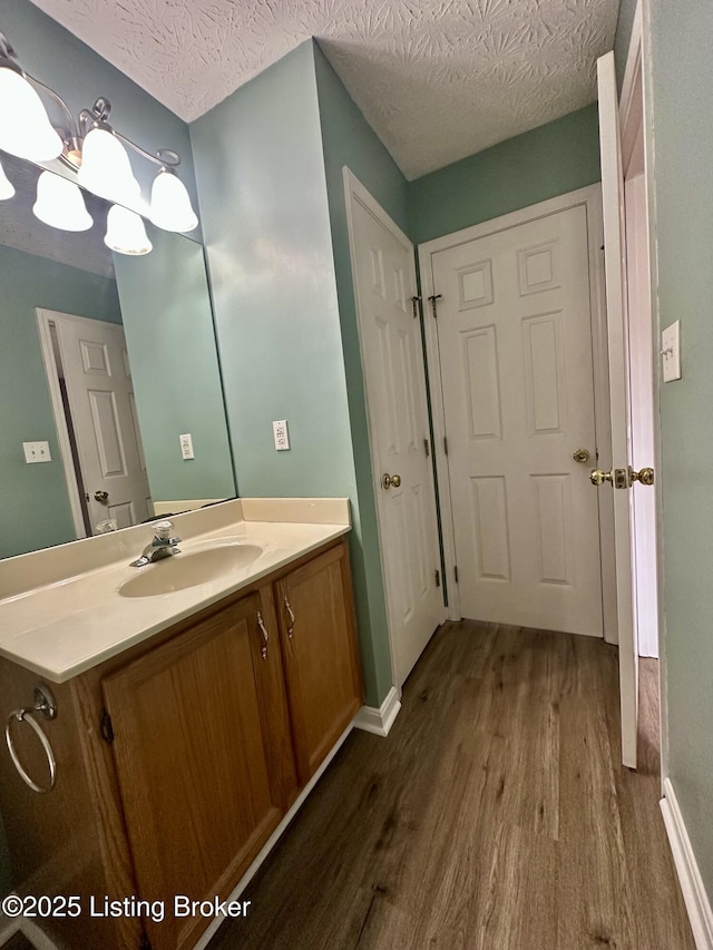 512 Auburn Oaks Dr, Louisville, KY 40214 - bathroom with wood finished floors, vanity, a textured ceiling, baseboards, and a chandelier