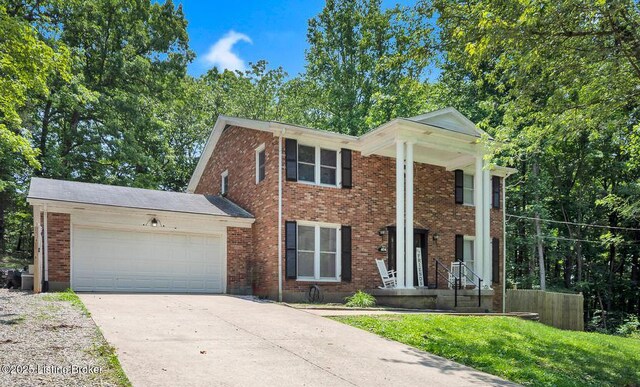 404 Bellemeade St, Brandenburg, KY 40108 - greek revival house with a garage, driveway, and brick siding