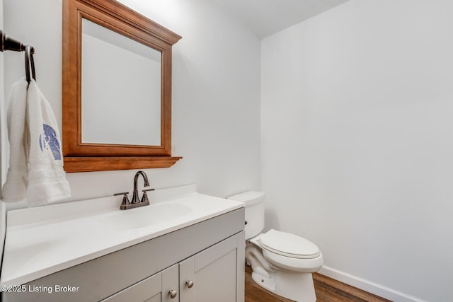 404 Bellemeade St, Brandenburg, KY 40108 - half bath featuring wood finished floors, vanity, toilet, and baseboards