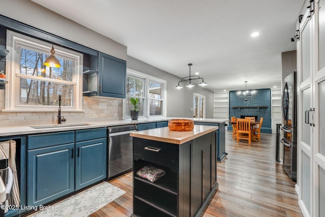 404 Bellemeade St, Brandenburg, KY 40108 - kitchen with appliances with stainless steel finishes, a sink, blue cabinetry, a center island, and light wood finished floors