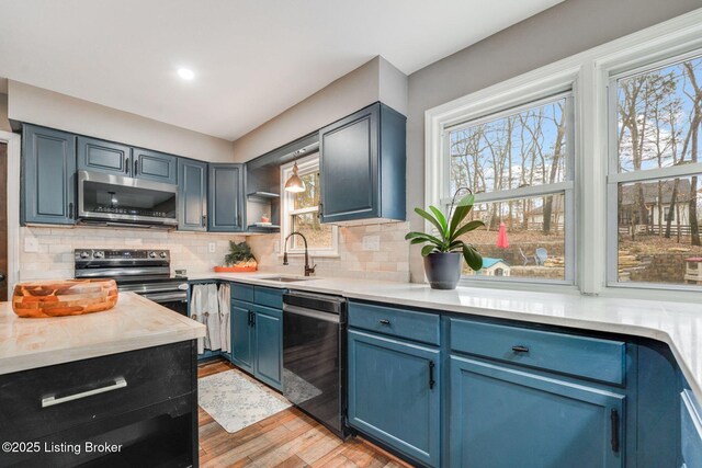 404 Bellemeade St, Brandenburg, KY 40108 - kitchen featuring appliances with stainless steel finishes, a sink, blue cabinets, and healthy amount of natural light