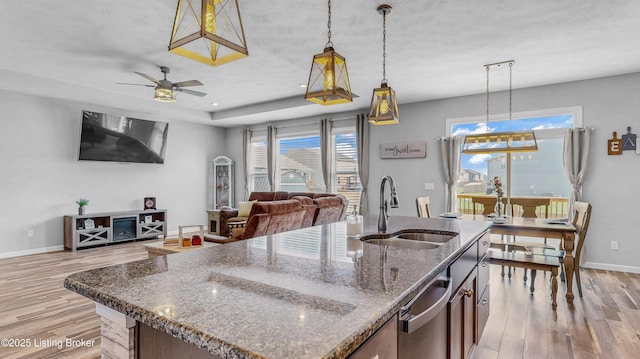 125 Bridlewood Dr, Shepherdsville, KY 40165 - kitchen with open floor plan, light wood-style flooring, hanging light fixtures, a center island with sink, and stainless steel dishwasher