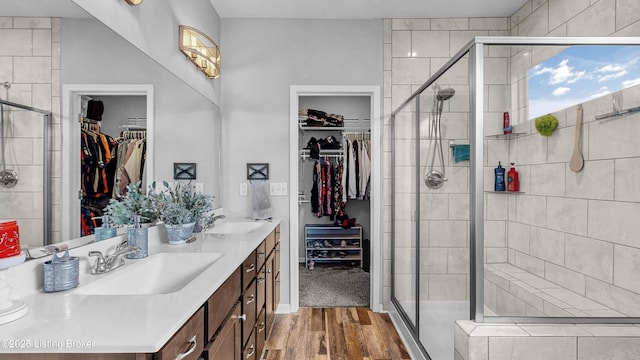 125 Bridlewood Dr, Shepherdsville, KY 40165 - full bathroom featuring double vanity, a walk in closet, wood finished floors, and a stall shower