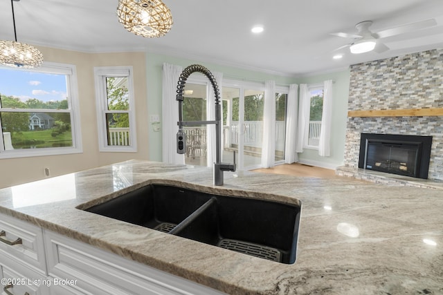 3205 Lake Pointe Ct, Crestwood, KY 40014 - kitchen with a sink, light stone countertops, crown molding, open floor plan, and a fireplace