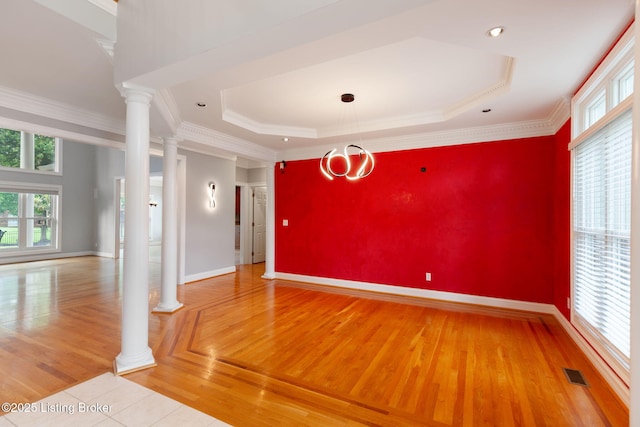 15108 Chestnut Ridge Cir, Louisville, KY 40245 - empty room featuring light wood-type flooring, baseboards, a raised ceiling, an accent wall, and ornamental molding